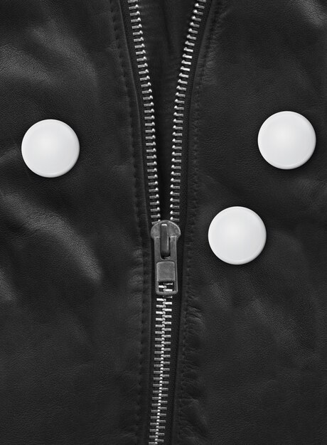 A close-up of a modular jacket. Zippers, buttons, and snaps allow different sections to be added or removed, showcasing its adaptability. The materials combine tech-inspired fabrics with organic textures.