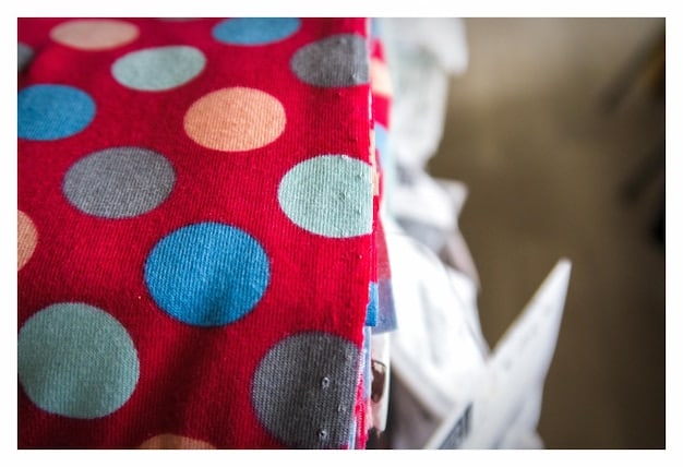 A close-up shot displaying various fabric swatches with different prints, including floral, stripes, polka dots, and geometric patterns. The swatches are arranged in a visually appealing manner, showcasing the variety and potential combinations for print mixing.