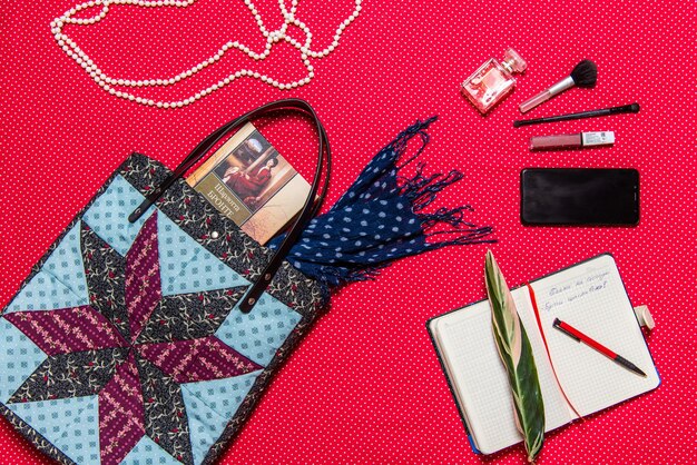 A flat lay showcasing a variety of accessories, including a statement necklace, a colorful scarf, a classic watch, a pair of sunglasses, and a versatile handbag.
