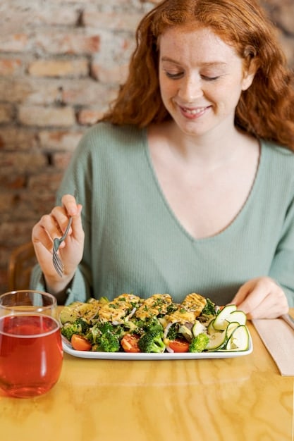A person mindfully eating a colorful salad with fresh vegetables. The focus is on the textures and colors of the food, with natural light enhancing the scene. The person is holding a fork, about to take a bite, with a calm and focused expression.