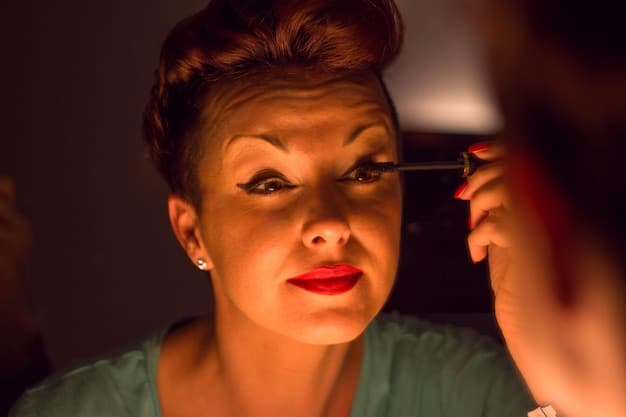 A makeup artist applying a highlighting stick along the cheekbone of a model. The light is catching the creamy texture of the product, showing a subtle shimmer. The model has fair skin and the artist is using a light peach-toned highlighter.
