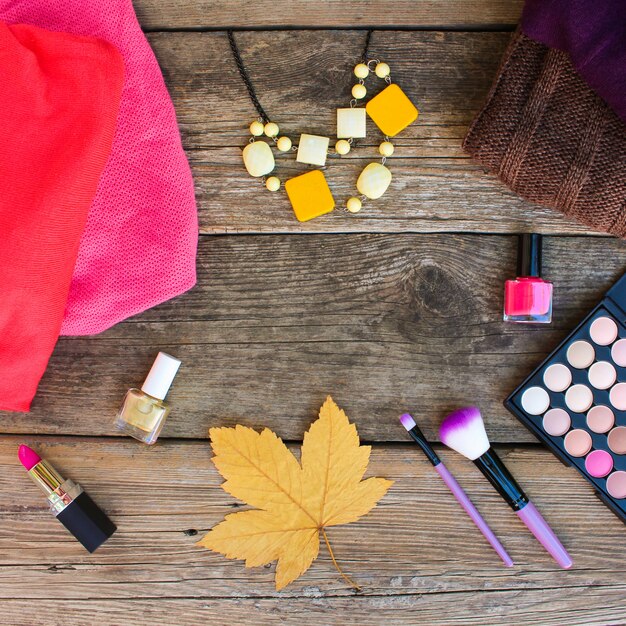 An overhead shot of a makeup table filled with various festival makeup products, including vibrant eyeshadow palettes, glitter pots, colorful eyeliners, and makeup brushes. The shot is well-lit and organized, showcasing the range of makeup options available for creating festival looks.