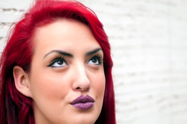 A woman with red monochromatic makeup. Her eyeshadow, blush, and lipstick all harmonise in similar tones of red creating a bold, beautiful and cohesive look which is very striking.