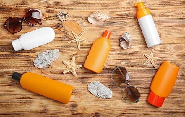 A collection of various sunscreen products, including lotions, sprays, and sticks, arranged on a table with skincare items. The scene is well-lit and focuses on the diversity of sunscreen options available.