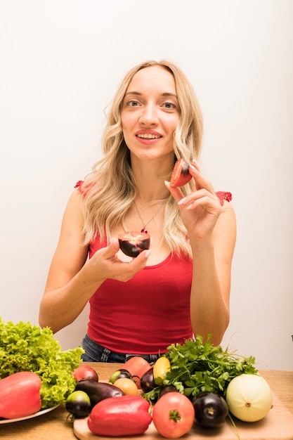 A young woman enjoying a healthy meal with fresh fruits and vegetables, emphasizing the importance of diet for skin health.