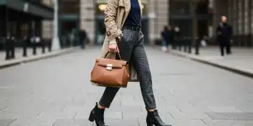 Woman in classic trench coat, tailored trousers, leather handbag, and ankle boots, embodying smart style investment.