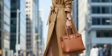 Woman in classic trench coat and leather bag, embodying timeless style.